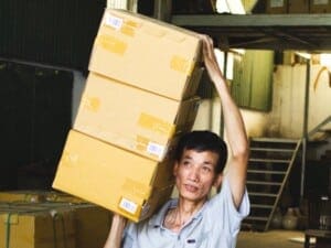 A worker loading cartons to load a container, Vietnam.