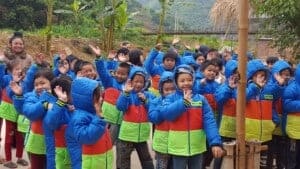 Children in Vietnam showing the new winter coats they received from Project Sprouts