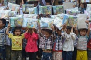 Children in Vietnam showing the school supplies they received from Project Sprouts