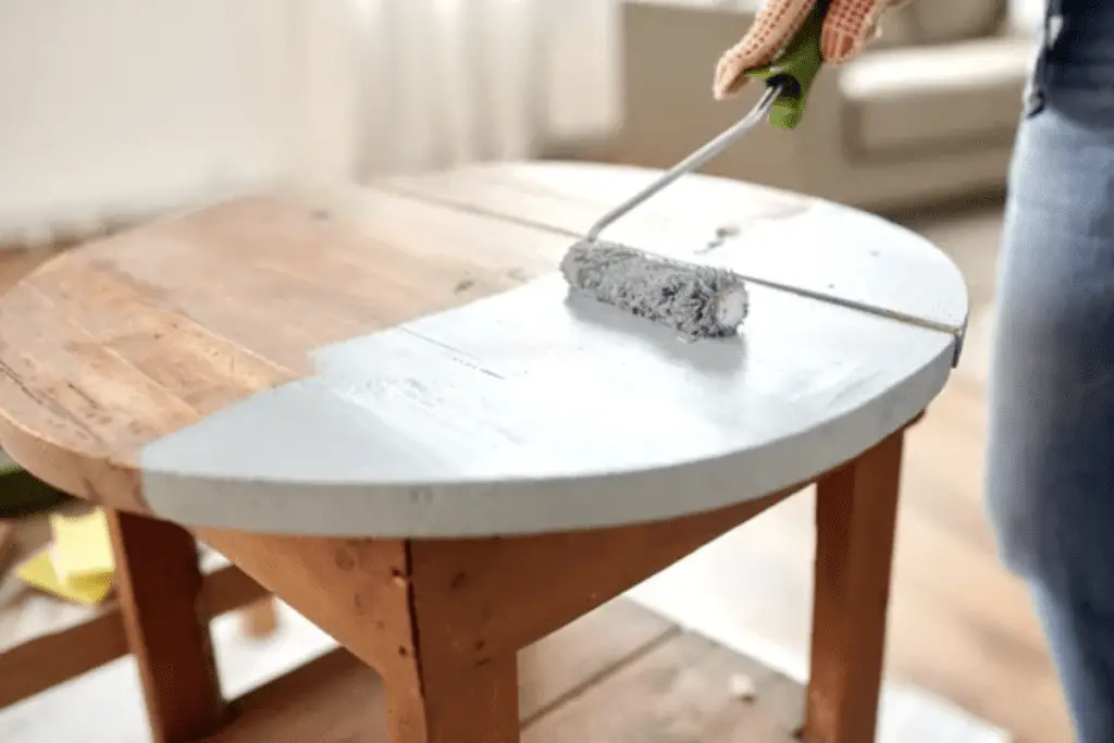 A man painting a table using a acrylic paint