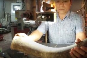 A worker cut the horn to create a design for it.