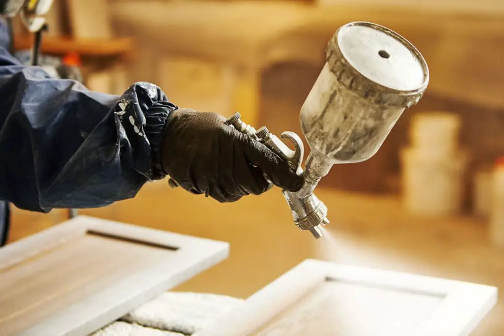 Applying lacquer paint to wooden furniture.